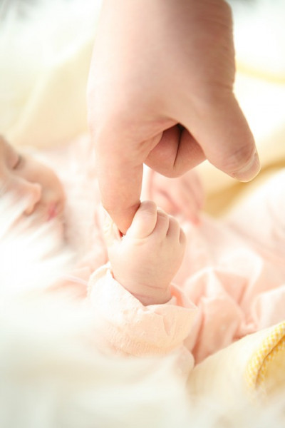 Baby hand and adult fingers