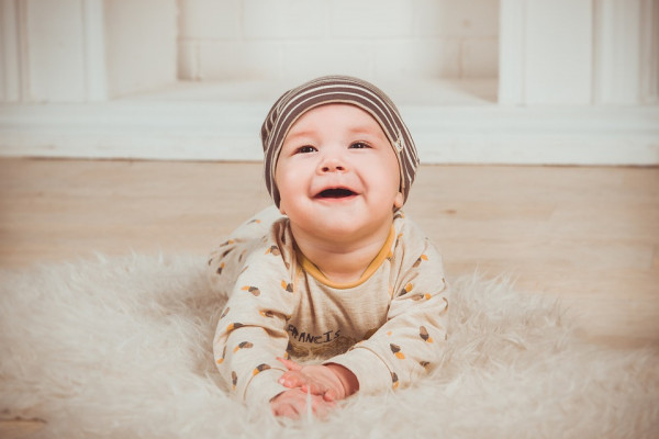 Baby krabbelnd und lachend auf Boden