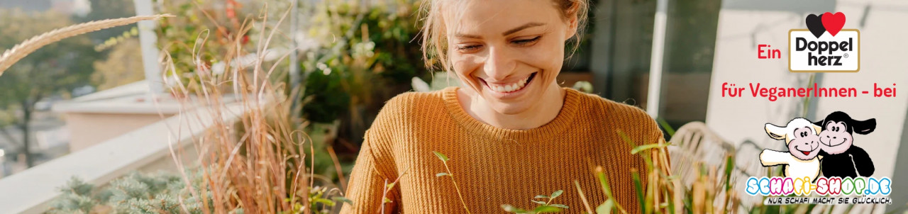 Un doble corazón para los veganos en Schafi-Shop. Mujer sonriente al sol en un balcón con hierbas y plantas
