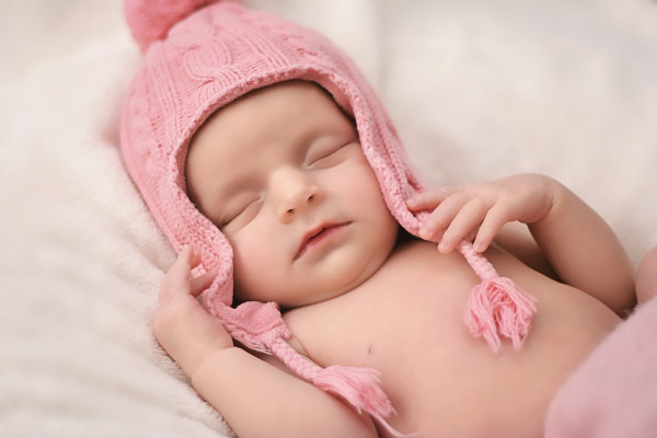 Bébé avec un bonnet rose
