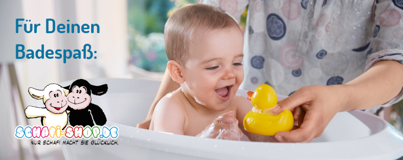 在浴缸里笑的婴儿和鸭子